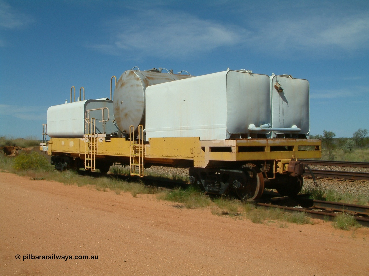 040419 102228
Abydos back track, riveted flat waggon 202 with three water tanks fitted, 3/4 view from non-handbrake end, shows access ladder profiles, originally part of the 'camp train', modified by Mt Newman Mining railway workshops.
Keywords: BHP-flat-waggon;