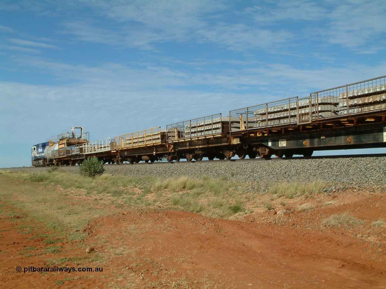 040502 085554
Mooka Siding, trailing view of the 'Pony' heading south, 50 ton waggon 6701, one of three 'special' waggons converted from Magor USA built ore waggons, loaded with concrete sleepers is in the middle with former Goldsworthy flat waggon 8704 closet to camera. 
Keywords: Magor-USA;BHP-pony-waggon;