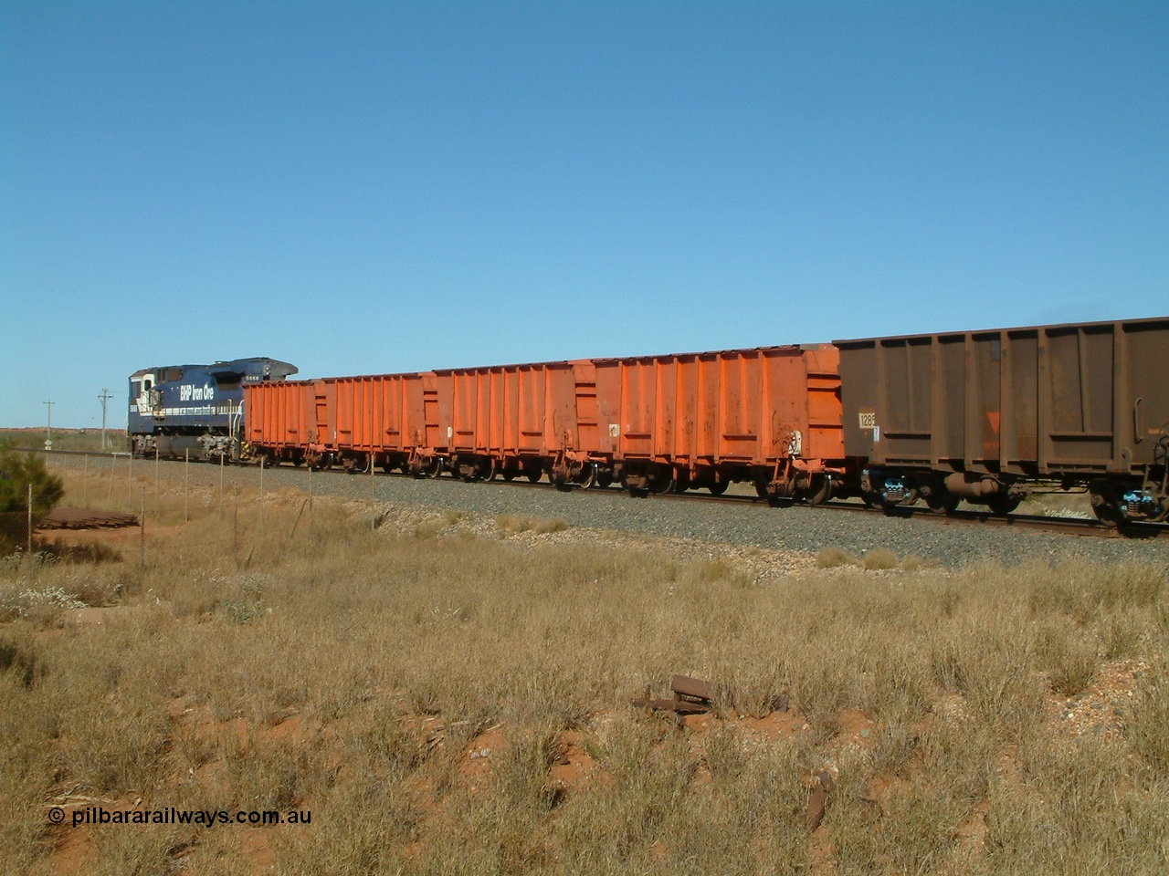 040806 091154
Goldsworthy Junction, trailing view of the weighbridge test train with the four orange weighbridge test waggons and two Comeng built ore waggons to provide braking, 5666 is the power.
