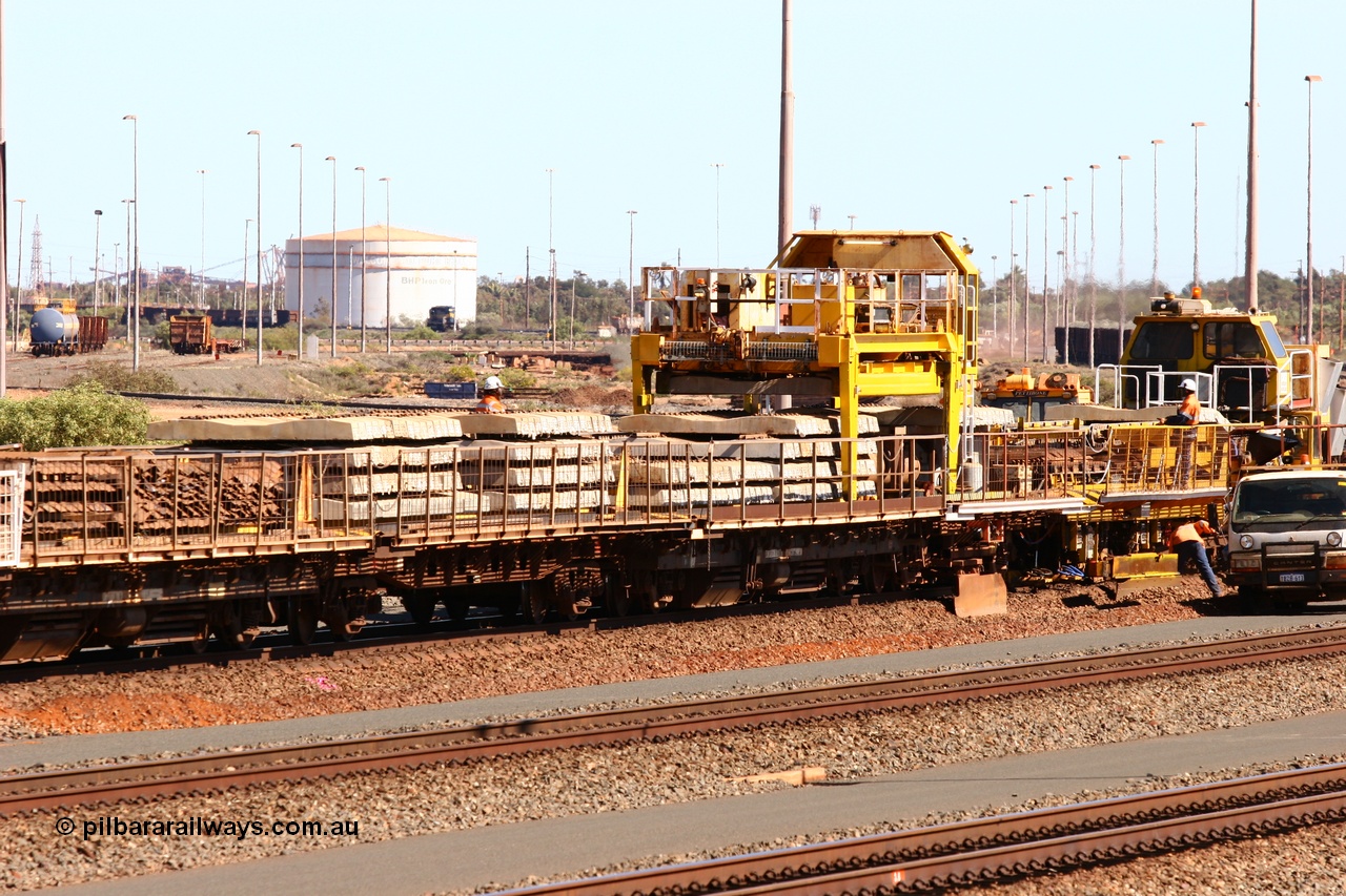 050724 4234
Nelson Point yard, flat waggons in service on the Pony re-laying train as transport waggons for sleepers, with a gantry car delivering concrete sleepers to replace the removed steel sleepers. The middle waggon is an ex Goldsworthy Mining flat waggon with a Scotts of Ipswich built flat either side, built in 1970 for then Mt Newman Mining Company.
Keywords: Scotts-Qld;BHP-pony-waggon;