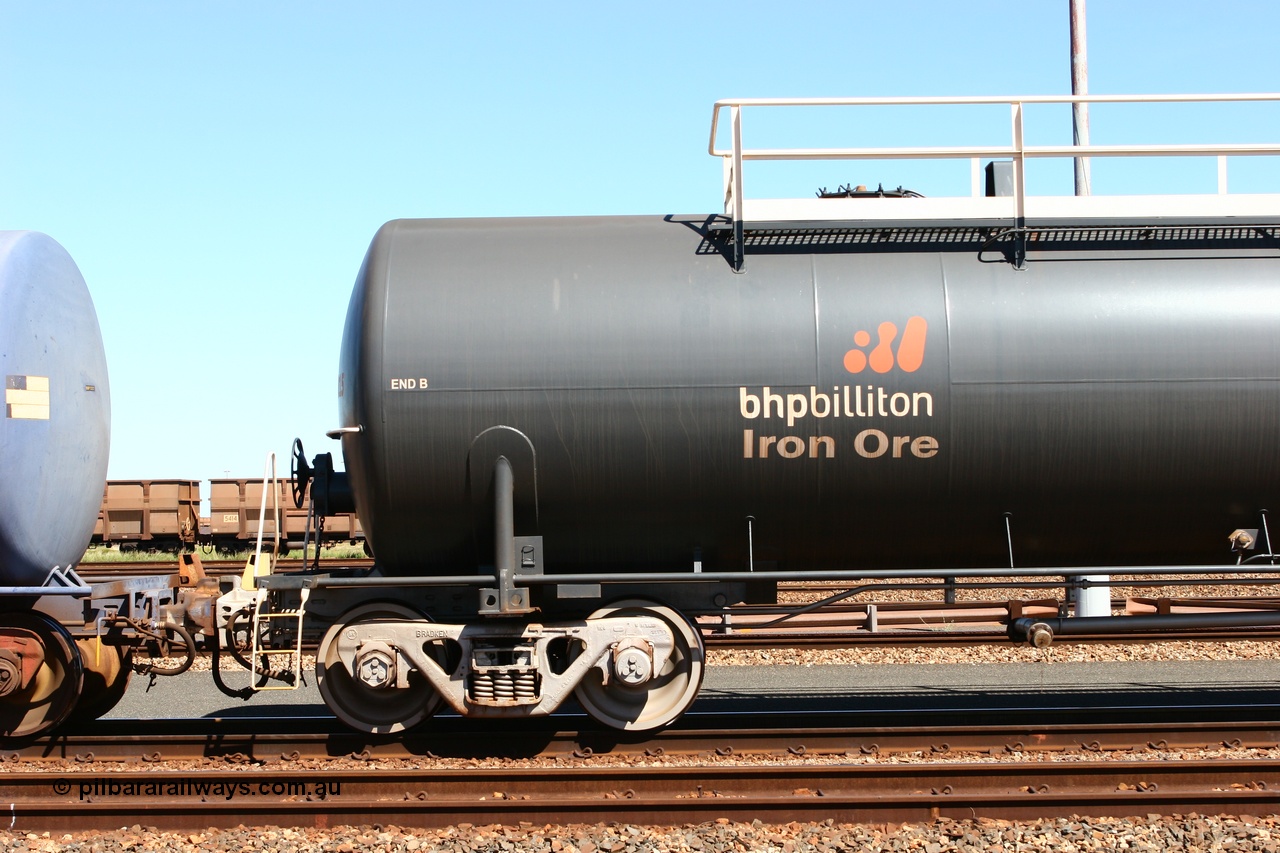 060414 3458
Nelson Point yard, empty fuel tank waggon 0015, view of B end and bogie, a Comeng WA built 116 kilolitre tank waggon, one of a batch of six built in 1974-75 wearing the newer corporate 'Earth' livery of BHP Billiton Iron Ore.
Keywords: Comeng-WA;BHP-tank-waggon;