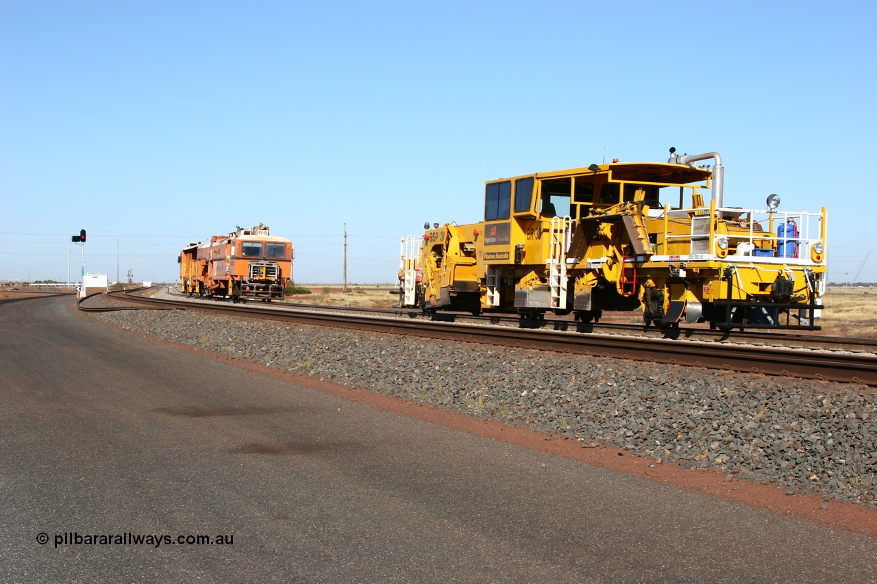 060710 6235
At the Broome Rd grade crossing Port Hedland, track machine BR 33 a Plasser Australia ballast regulator model SSP 302 serial M486 follows Plasser Australia Unimat S4 switch tamper SW 02 as the head south. 10th July 2006.
Keywords: track-machine;