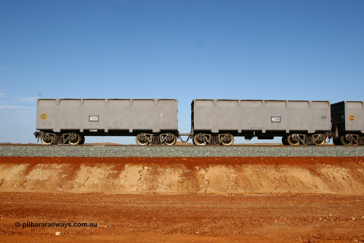 080116 1365
Chapman Siding at the 69 km on FMG's under construction line to Cloud Break mine, new waggons stabled in the passing track awaiting service, built by China Southern or CSR at their Zhuzhou Rolling Stock Works in China in 2007, here slave waggon 1395 and master waggon 2396 sit in the arvo sunlight. The yellow circle indicates the rotary coupler end and the tare weight of the slave waggon at 22.6 tonnes, while the master weighs 22.9 tonnes as it hosts the brake control equipment. 16th January 2008. 
Keywords: 1395-2396;CSR-Zhuzhou-Rolling-Stock-Works-China;FMG-ore-waggon;