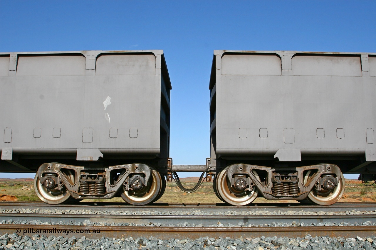 080116 1373
Chapman Siding, view showing the bogies and bar coupling, train pipe, control pipe and electrical jumper of FMG married pair of slave 1395 on the left and master 2396 on the right. The BHP Newman line in the back ground. 16th January 2008.
Keywords: FMG-ore-waggon;