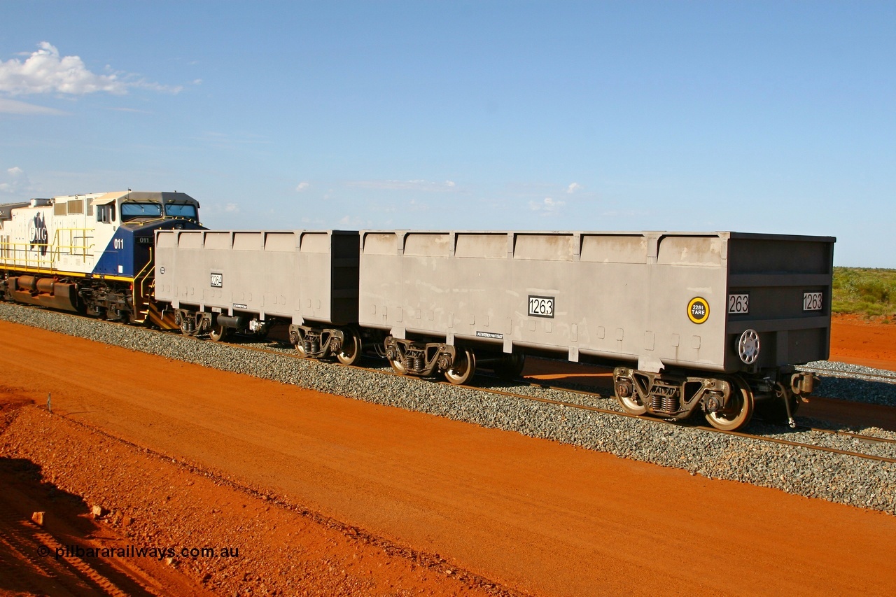 080120 1469
Thomas Yard, new FMG ore waggon pair 1263 slave and 2264 control waggons, 22.6 tonnes tare with rotary coupler, and the master at 22.9 tonnes. View from the handbrake end coupled to a GE Dash 9-44CW unit 011. 20th January 2008.
Keywords: 1263-2264;CSR-Zhuzhou-Rolling-Stock-Works-China;FMG-ore-waggon;
