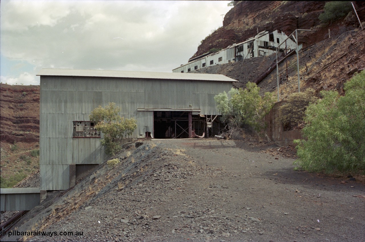 194-01
Wittenoom Gorge, Colonial Mine, asbestos mining remains, view of building that houses the crusher, slide chute for conveying ore from the waggons from the upper level is visible, along with upper level buildings for the miners and railway.
