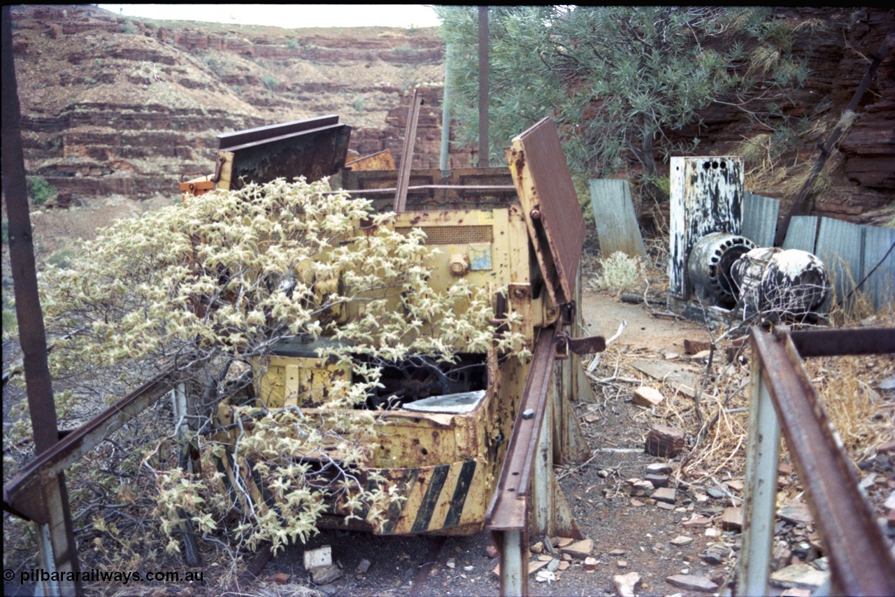 194-19
Wittenoom, Colonial Mine, asbestos mining remains, English Electric battery locomotive hauler and No.1 battery compartment open with batteries removed, workshops area, GEMCO Hauler behind it. Small MG DC generator set for battery charging behind at right, gorge in the background looking south.
