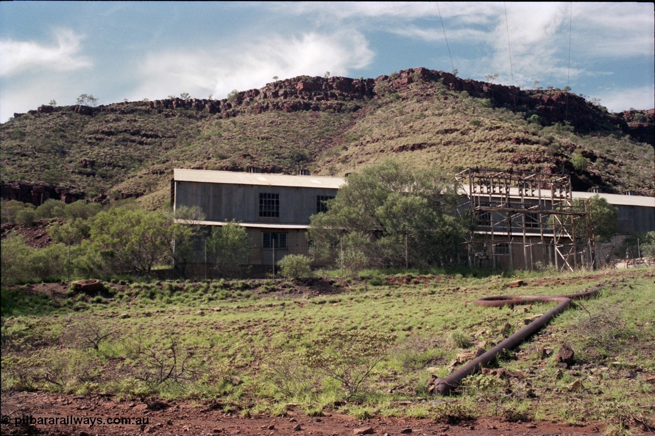 196-25
Wittenoom Gorge, view of power station generating hall with high voltage aerial conductors and the cooling water pipe visible.
