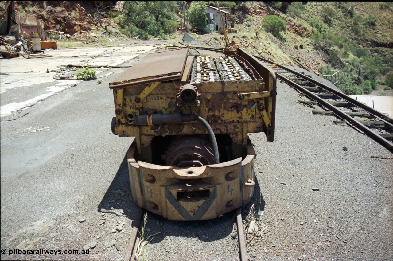 197-13
Wittenoom, Colonial Mine, asbestos mining remains, Mancha battery locomotive #4 looking north west, demolished workshops and office on the left, mine adit doors visible, compressor building in the distance.
Keywords: Mancha;