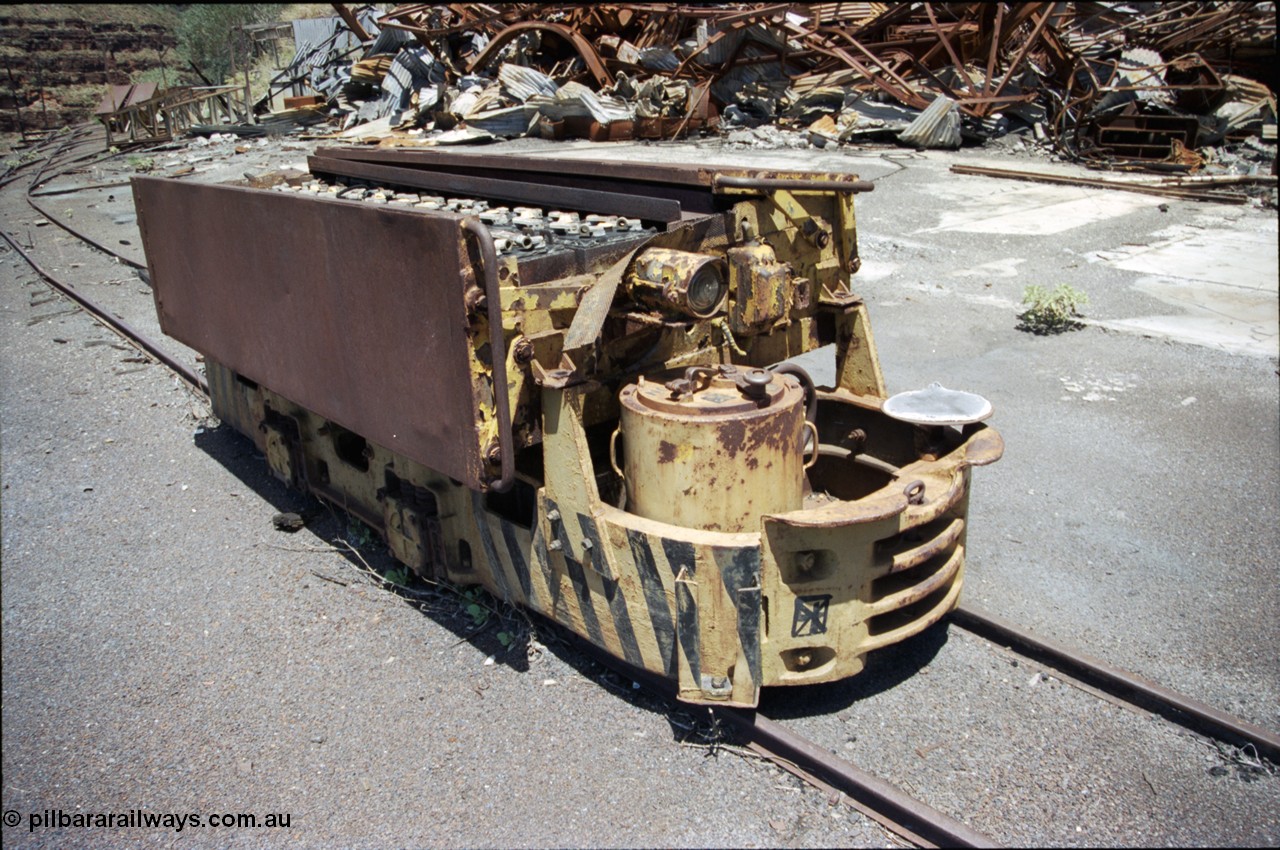 197-16
Wittenoom, Colonial Mine, asbestos mining remains, Mancha battery locomotive #4 looking south east, demolished workshops and office behind with the battery charging shed remains in the distance. Drivers seat, brake wheel and controller visible.
Keywords: Mancha;