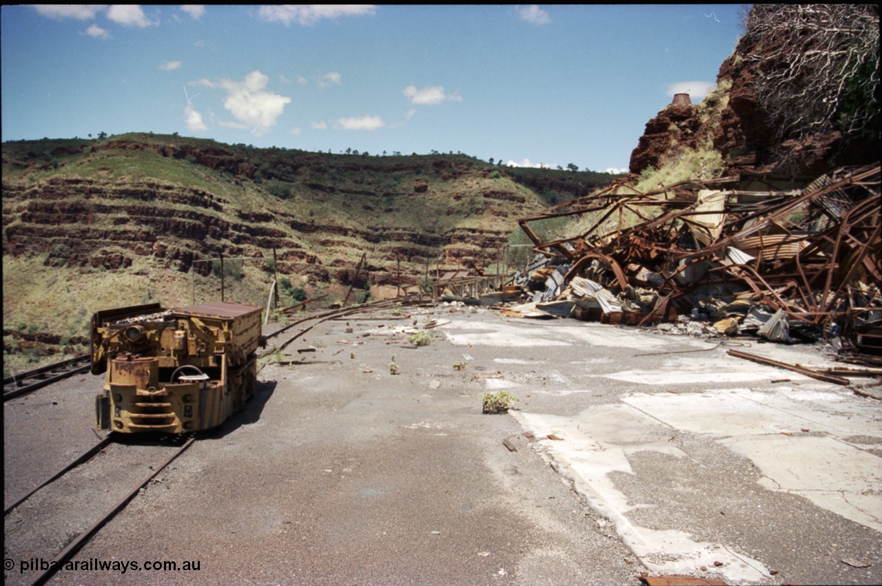 197-19
Wittenoom, Colonial Mine, asbestos mining remains, view looking south east with the demolished underground shit offices and workshops, Mancha battery locomotive #4 and the battery charging shed remains just visible in the distance.
Keywords: Mancha;