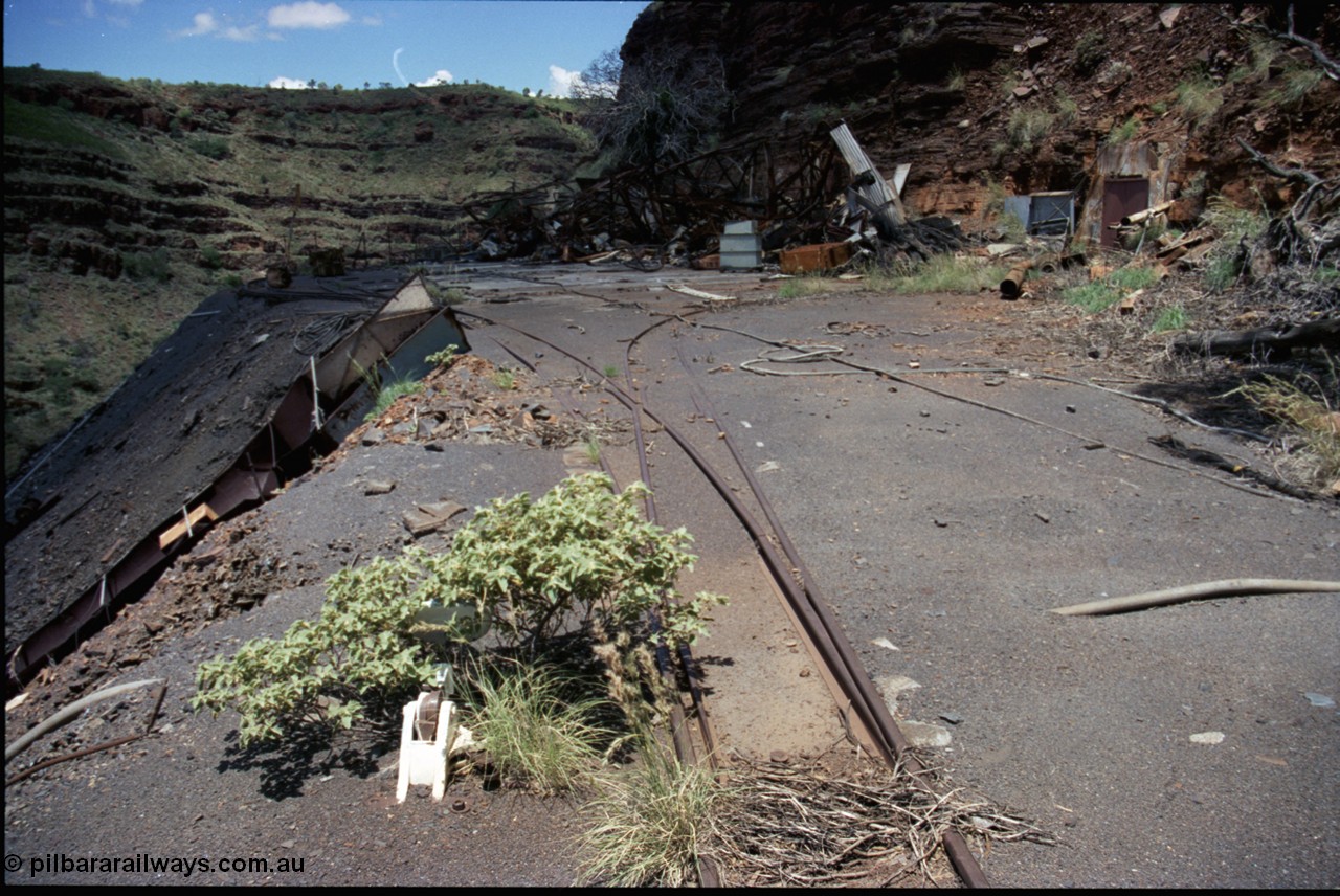 197-23
Wittenoom, Colonial Mine, asbestos mining remains, view of the points leading to the mine adit on the right, and past the discharge slide chute on the left. The loop road is visible in the distance, with the demolished underground offices and lamp room pushed up against the gorge wall. Mancha #4 in the distance.
Keywords: Mancha;
