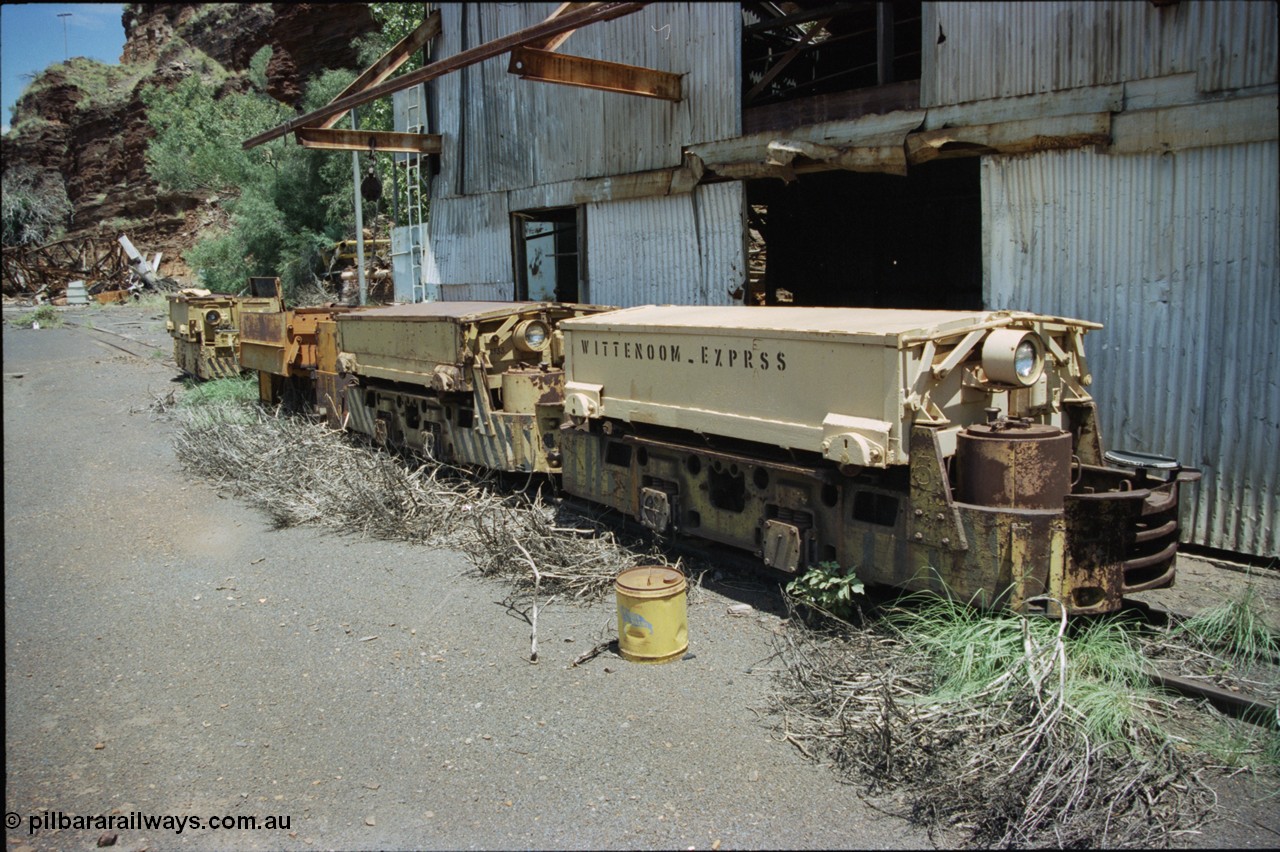 197-32
Wittenoom, Colonial Mine, asbestos mining remains, line up of two Mancha locomotives and the Gemco, then an English Electric. In the background is the demolished locomotive changing and maintenance shed. The building on the right are more workshops, the lead unit has Wittenoom Express stencilled on the battery box, this unit now resides at the Pilbara Railways Historical Society 6 Mile Museum near the Rio Tinto 7 Mile complex in Dampier.
Keywords: Mancha;English-Electric;Gemco;