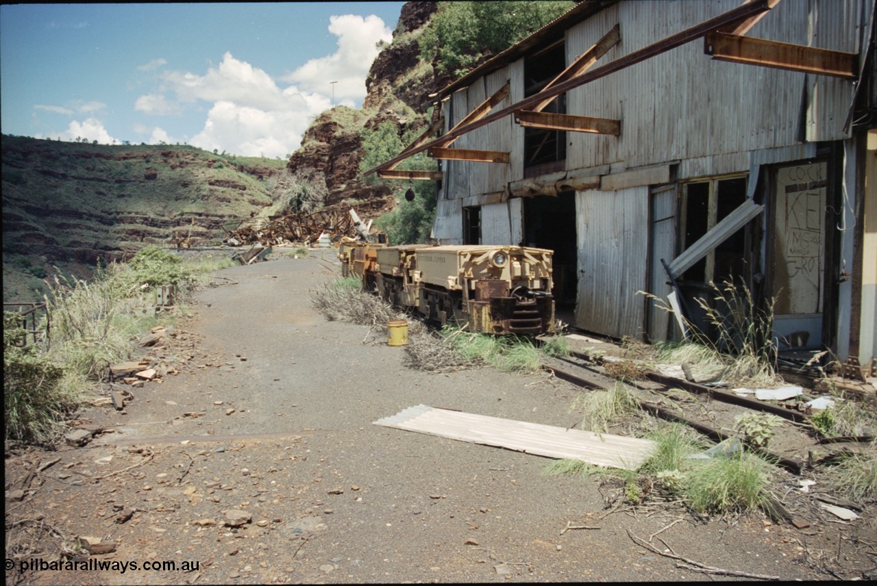 198-06
Wittenoom, Colonial Mine, asbestos mining remains, line up of two Mancha locomotives and the Gemco, then an English Electric unit. The compressor and water treatment plant is beside the locos, In the distance is the demolished locomotive changing and maintenance shed and underground offices and lamp room.
Keywords: Mancha;English-Electric;Gemco;