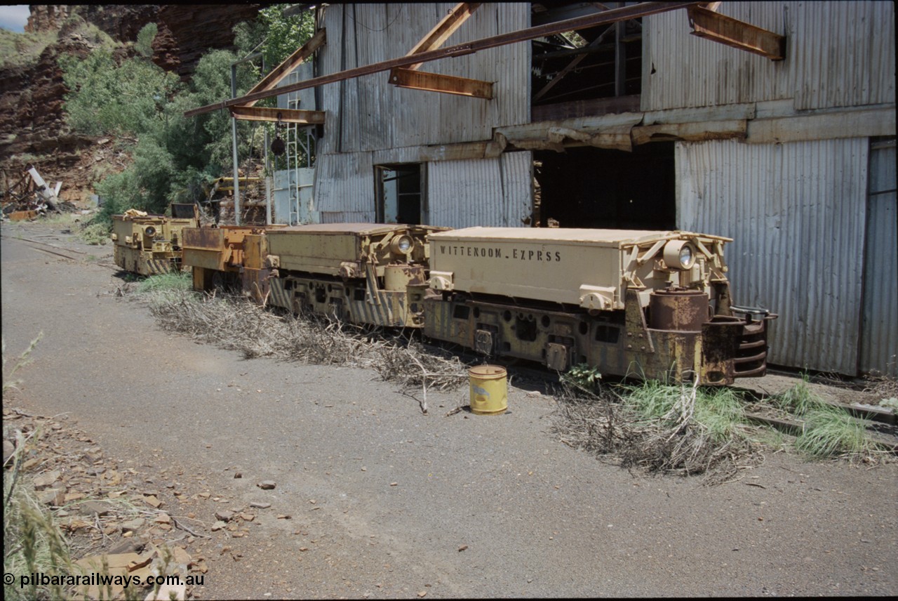 198-08
Wittenoom, Colonial Mine, asbestos mining remains, line up of two Mancha locomotives and the Gemco, then an English Electric. In the background is the demolished locomotive changing and maintenance shed. The building on the right is the compressor and water treatment plant sheds, the lead unit has Wittenoom Exprss stencilled on the battery box, this unit now resides at the Pilbara Railways Historical Society 6 Mile Museum located near the Rio Tinto 7 Mile complex at Dampier.
Keywords: Mancha;English-Electric;Gemco;