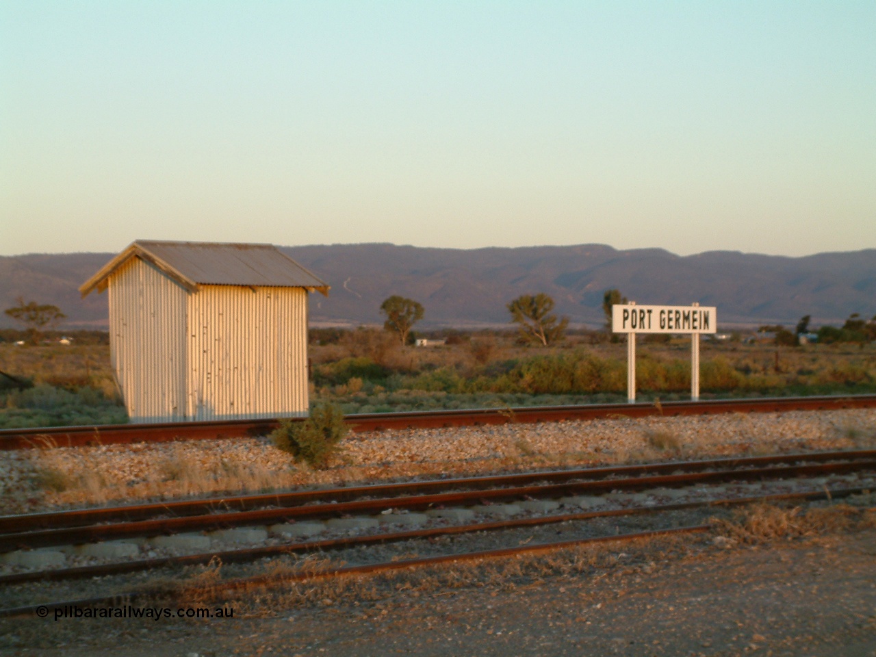 030403 180231
Port Germein, twilight shot of station name board and waiting shelter, Flinders Ranges form the backdrop.
