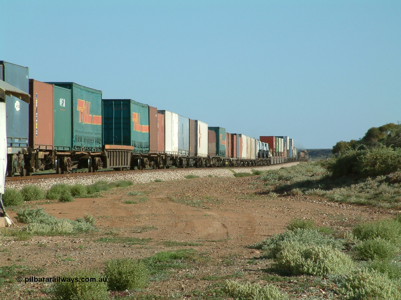 030404 082917
Port Germein, Perth bound steel and intermodal hurries through on the main behind National Rail's NR class units, showing one and a half stacking and new vehicles on flat waggons. 4th April 2003.
