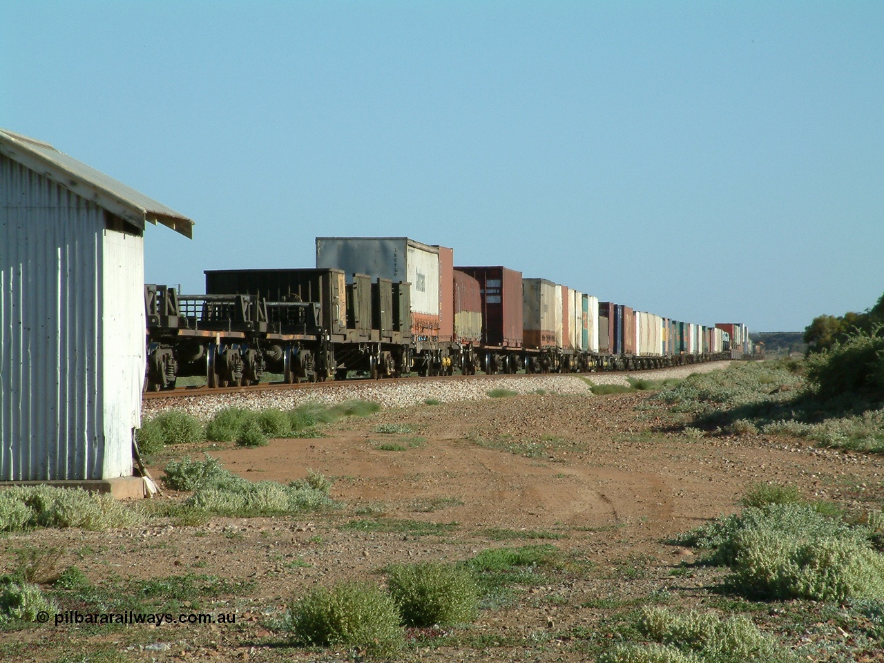 030404 082938
Port Germein, Perth bound steel and intermodal hurries through on the main behind National Rail's NR class units, showing one and a half stacking and new vehicles on flat waggons with empty steel loading on the rear. 4th April 2003.

