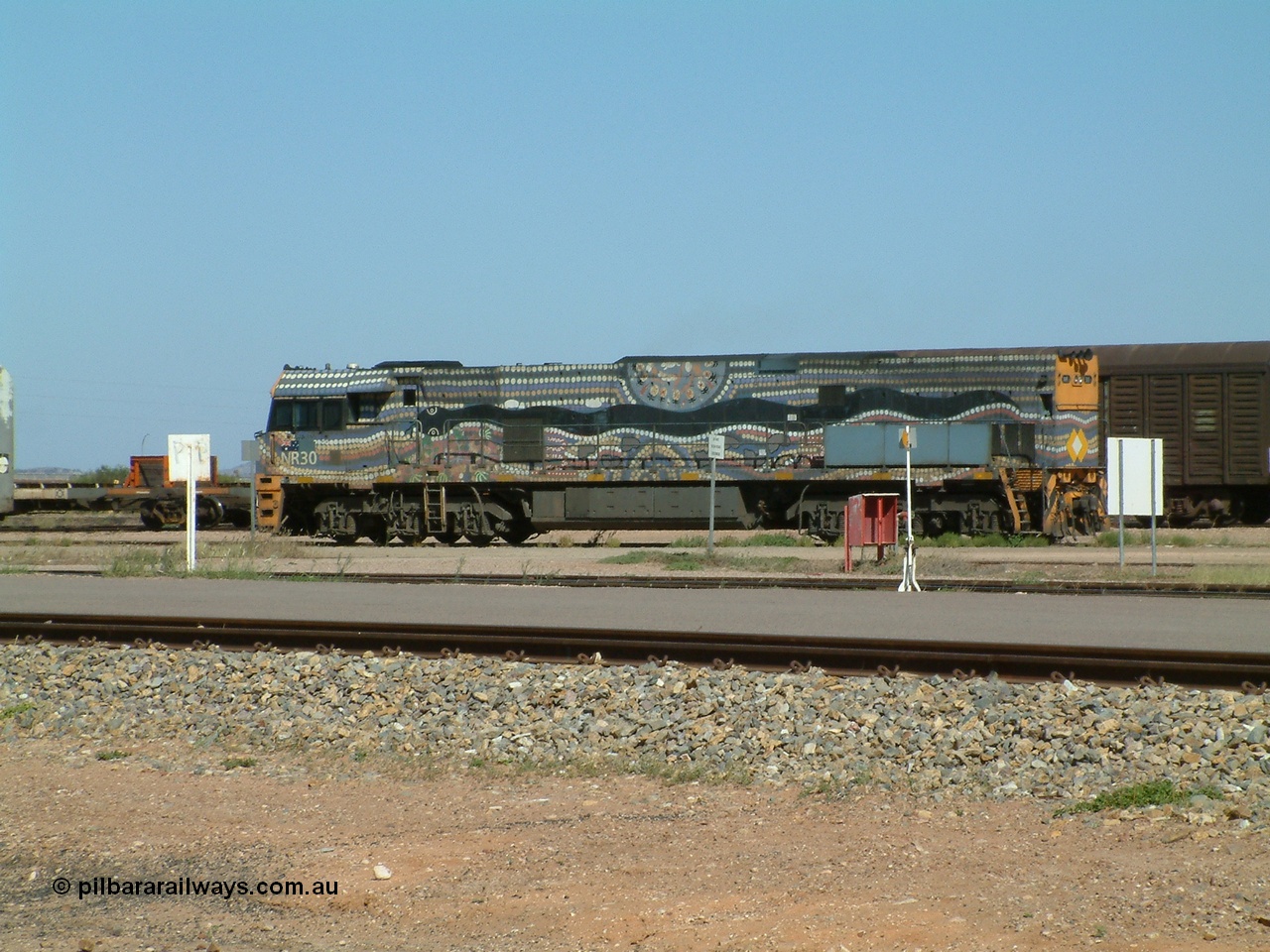030404 103000
Port Augusta, Goninan built GE model Cv40-9i NR class unit NR 30 serial 7250-05 / 97-232 was painted in a Bessie Liddle of Alice Springs designed aboriginal livery titled 'Warmi' or the snake, John Moriarty of Balarinji Design did the artwork.
Keywords: NR-class;NR30;Goninan;GE;Cv40-9i;7250-05/97-232;