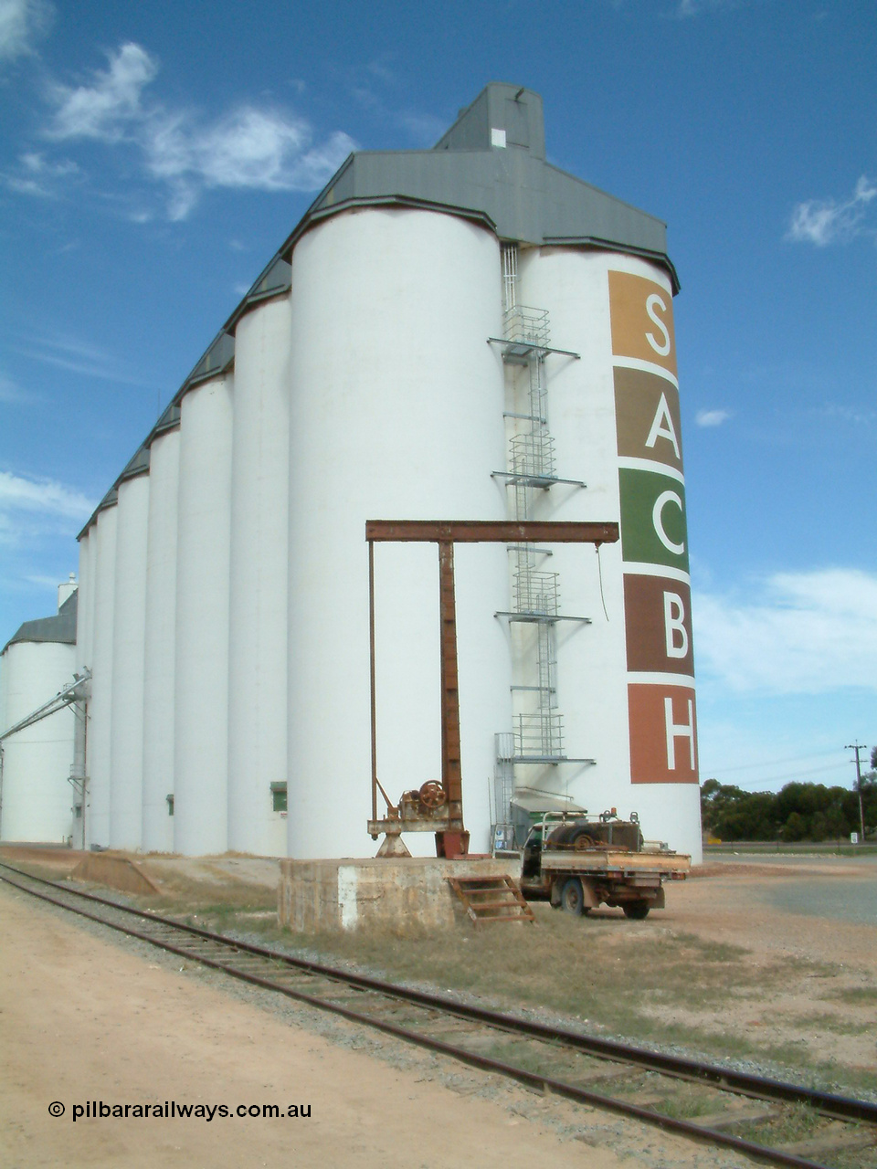 030405 132956
Wudinna, view of the 5 ton revolving jib yard crane and loading ramp with the SACBH silo complex behind and the narrow gauge siding in the foreground, 5th April 2003.
