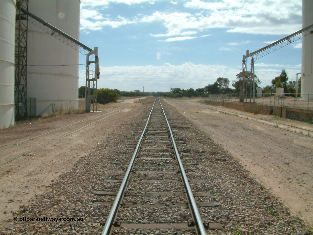 030405 140124
Kyancutta, yard view looking north along the mainline with silo out-loading spouts on each siding, 5th April 2003.
