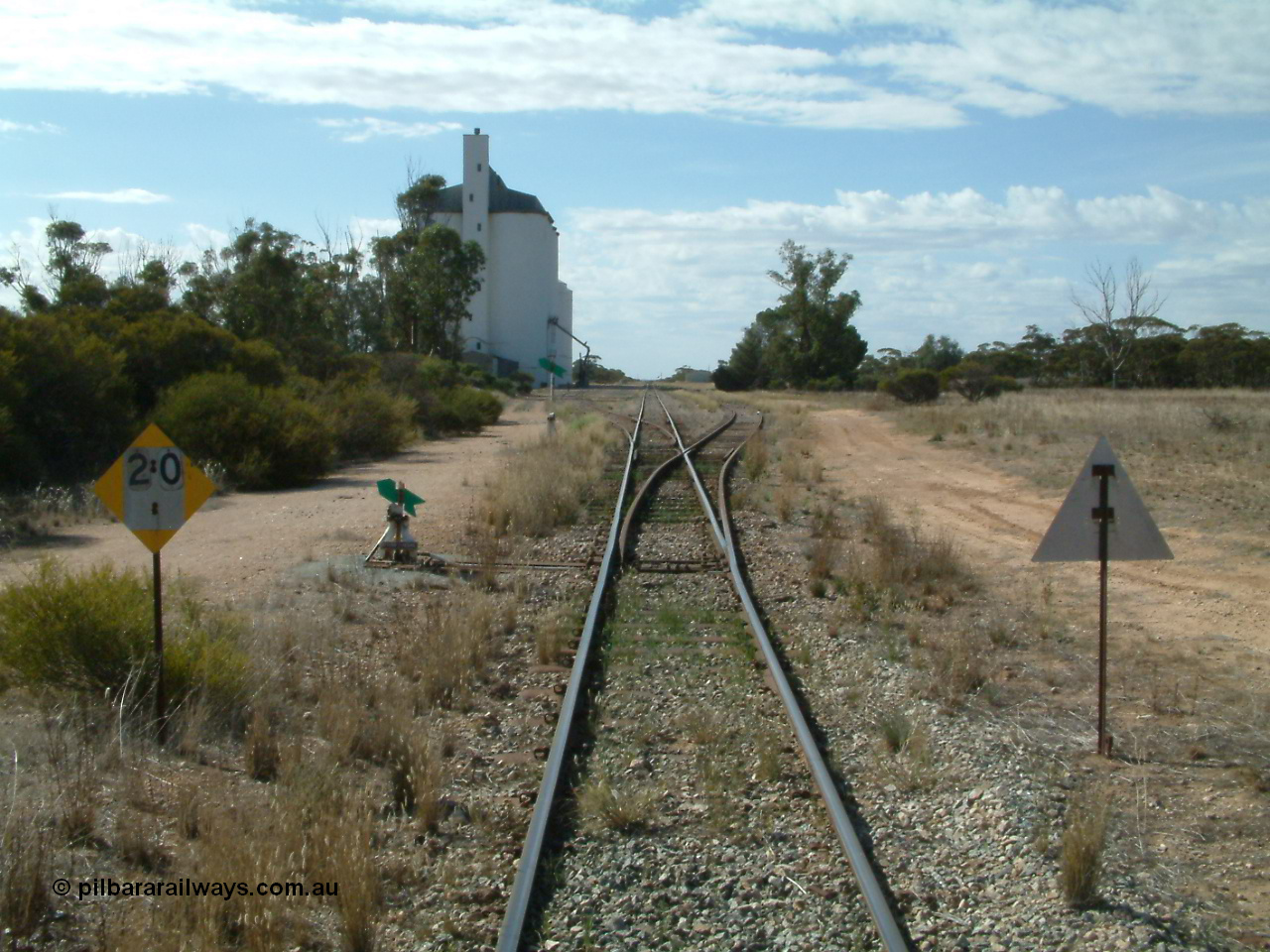 030405 150340
Warramboo, yard overview looking north with siding point levers and indicators, 20 km/h speed restriction signs, concrete SACBH silo complex on the left, 5th April 2003.
