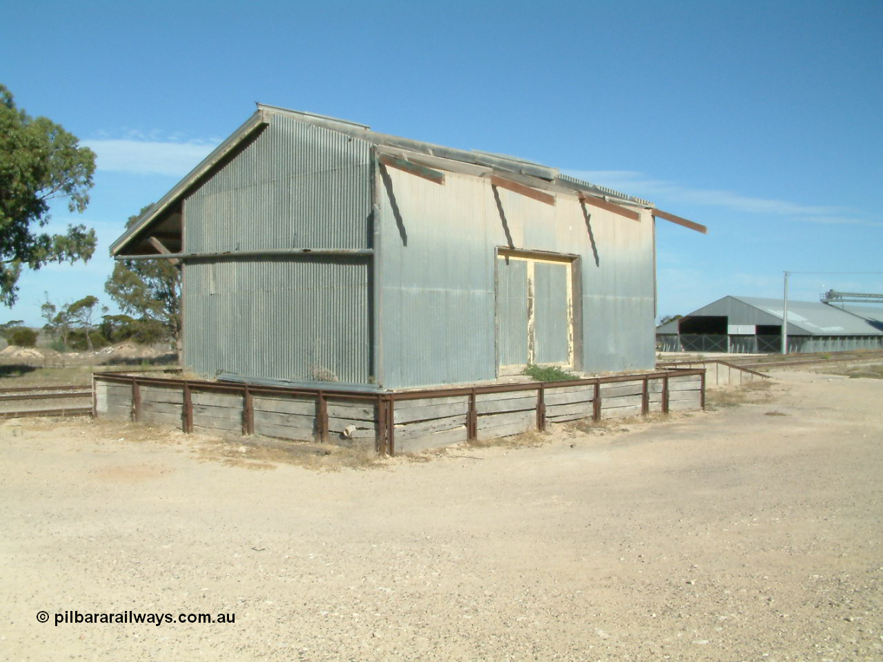 030405 155007
Lock, view of the goods shed and platform dating from circa 1938 with half the roof missing, horizontal grain shed visible in the background, 5th April 2003.
