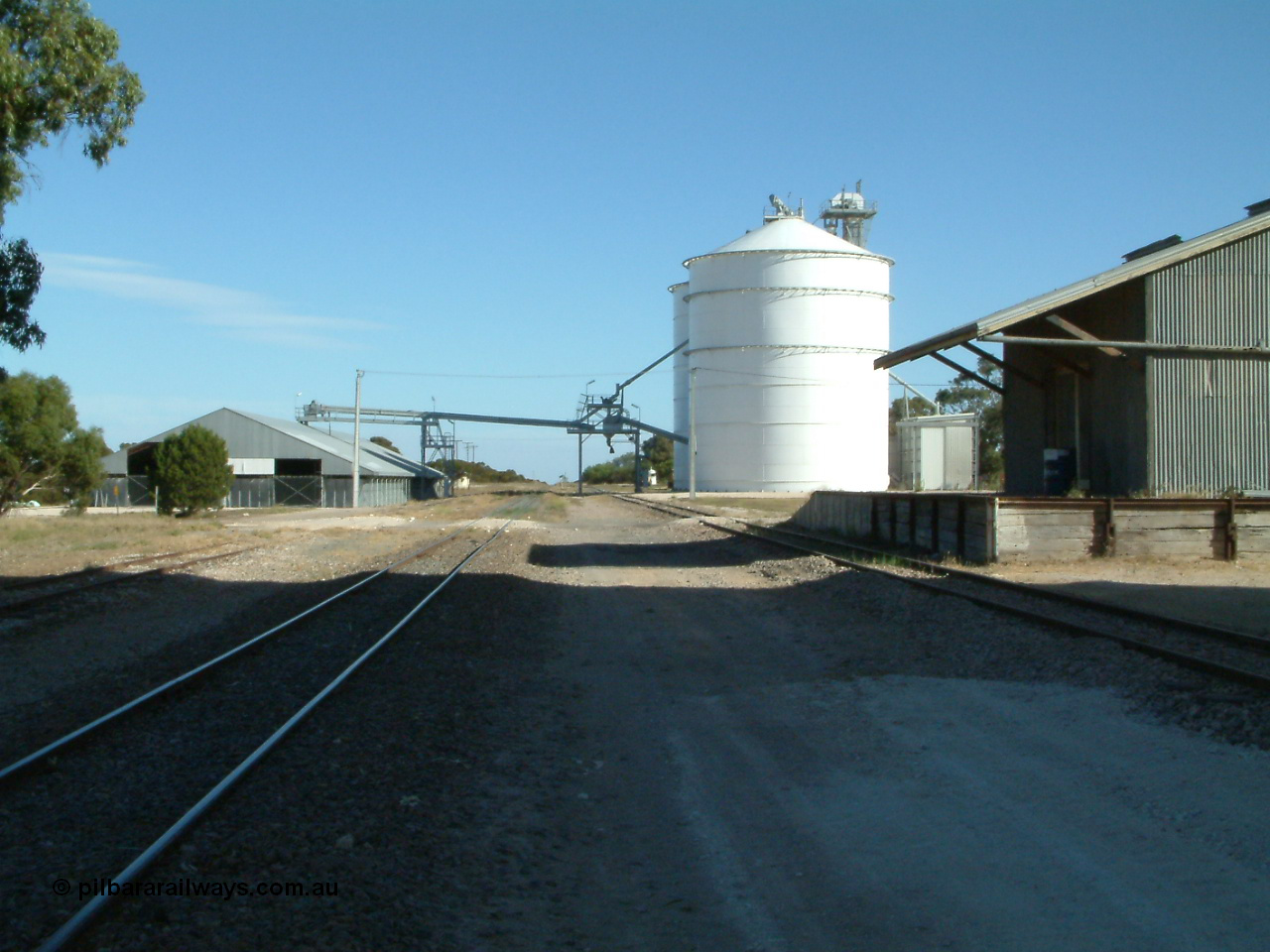 030405 155511
Lock, yard overview looking south along the mainline, horizontal grain shed with siding on the left, Ascom style silo complex Block 5 with outflow spout on the right with goods shed and platform also visible. 5th April 2003.
