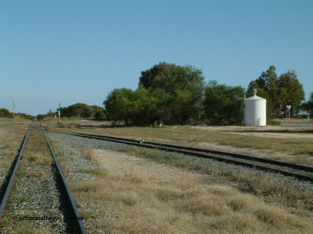 030405 155852
Lock, yard view looking south, grain silo siding point lever and indicator with derail, circular concrete toilet for grain complex, grade crossing for Birdseye Hwy visible in the distance. 5th April 2003.

