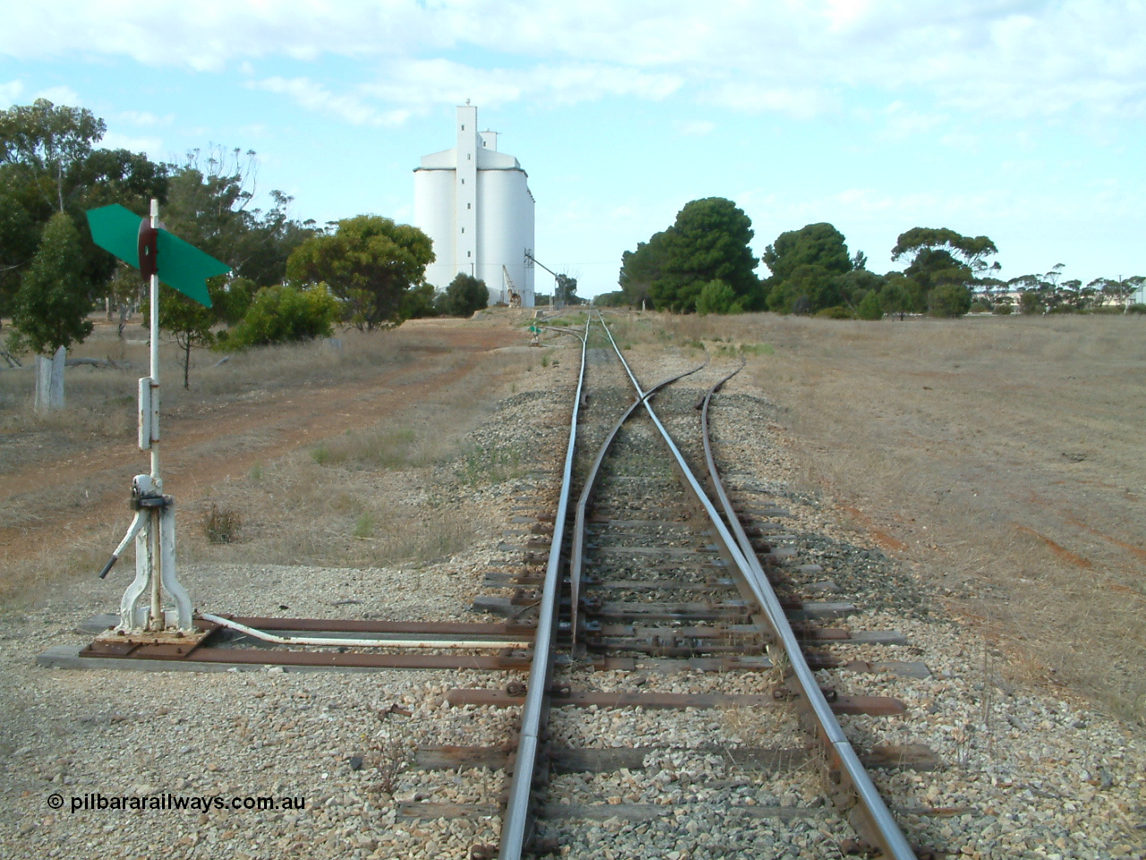 030406 091232
Yeelanna, station located at the 81.7 km, original terminus of line in April 1909, then junction for line to Mount Hope in October 1914. Station yard overview from the north end points looking south, point lever and indicators, goods ramp, crane and concrete silo complex on the left. 6th April 2003.
