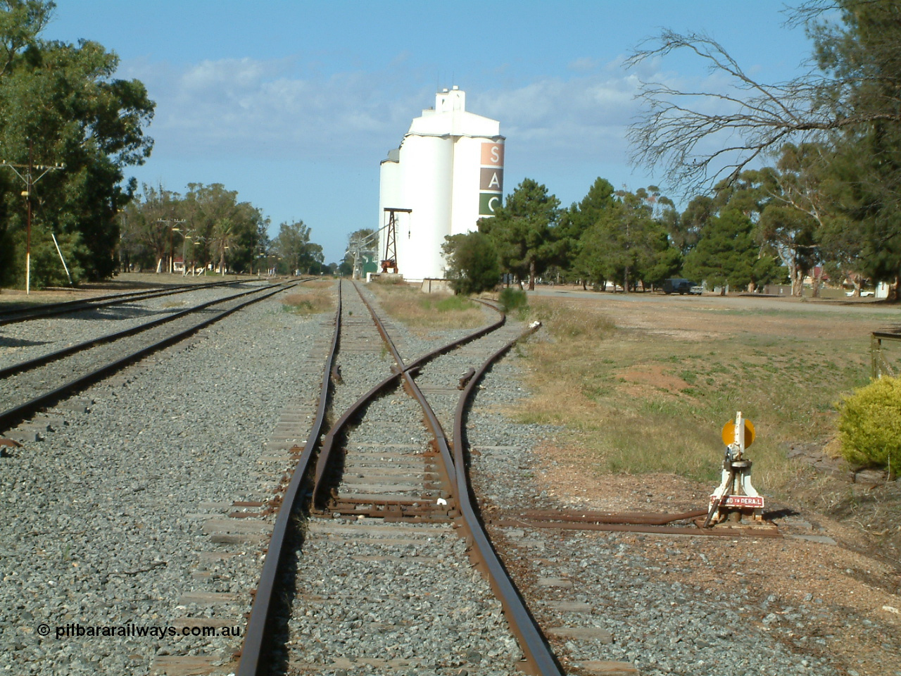 030406 094331
Cummins, yard view looking south along the grain siding with the points, lever and indicator for the goods loading ramp siding, formation of former triangle can be seen as the mound curving away to the right. 6th April 2003.
