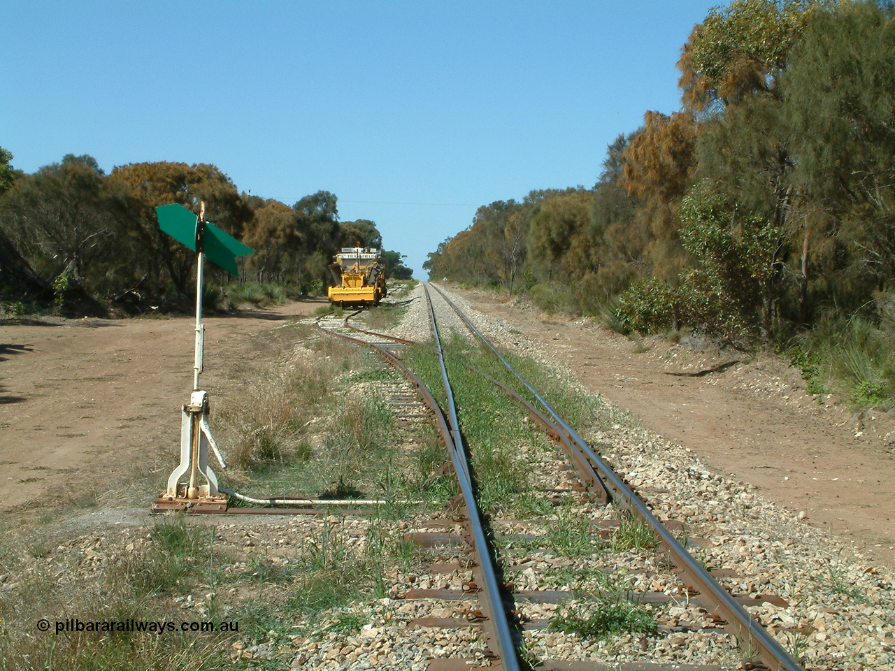 030406 110950
Coomunga, station located at the 21.6 km, opened in November 1907, used these days as a track maintenance siding. Yard overview looking south from the north end points, track machines on the left. 6th April 2003.
