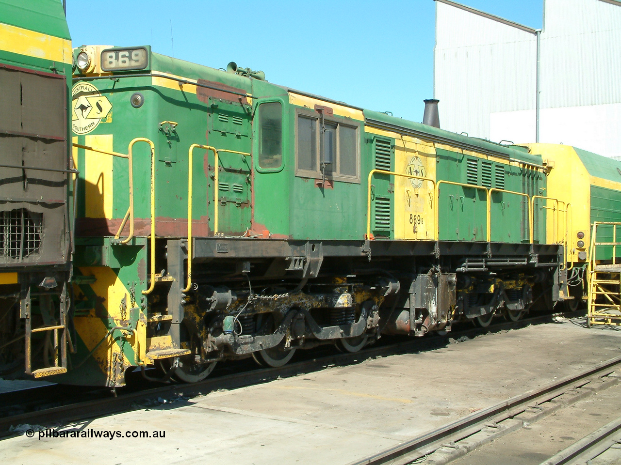 030406 113830
Port Lincoln loco workshops, still wearing the former owner's AN livery, Australian Southern locomotive 830 class 869 AE Goodwin ALCo model DL531 serial G6016-05 with the check letter of B, sandwiched between two NJ class units. 6th April 2003.
Keywords: 830-class;869;AE-Goodwin;ALCo;DL531;G6016-5;