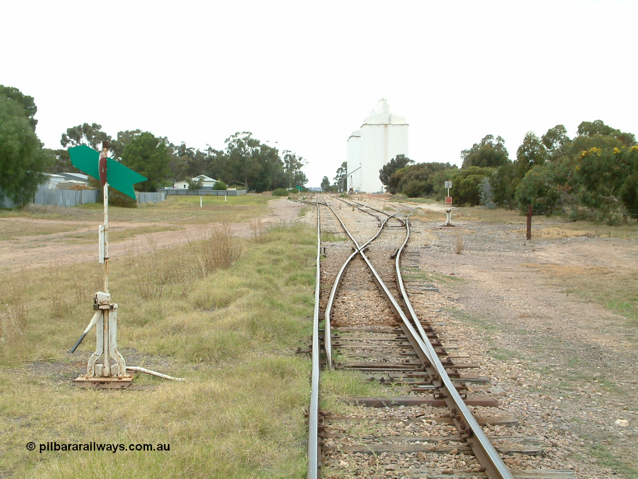 030407 095119
Minnipa, station yard overview looking south from the north end points, point levers and indicators for Sidings 1, 2 and 3 visible. Concrete silo complexes and rotating jib crane visible in the distance. 7th April 2003
