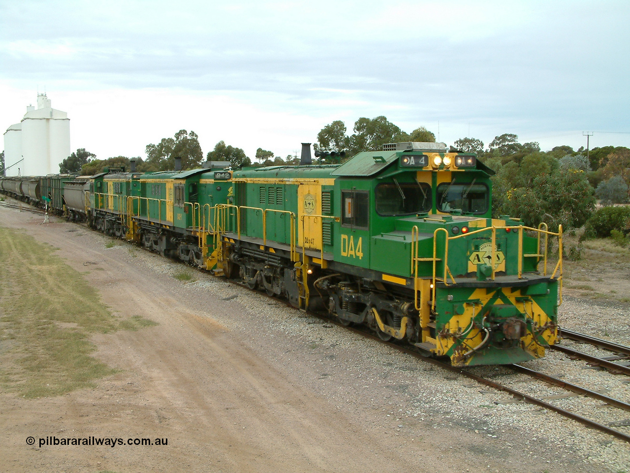 030407 100445
Minnipa, north bound empty grain train arrives behind a trio of former Australian National Co-Co locomotives with rebuilt former AE Goodwin ALCo model DL531 830 class ex 839, serial no. 83730, rebuilt by Port Augusta Workshops to DA class, leading two AE Goodwin ALCo model DL531 830 class units 842, serial no. 84140 and 851 serial no. 84137, 851 having been on the Eyre Peninsula since delivered in 1962, to shunt off empty waggons into the grain siding. 7th April, 2003.
Keywords: DA-class;DA4;83730;Port-Augusta-WS;ALCo;DL531G/1;830-class;839;rebuild;