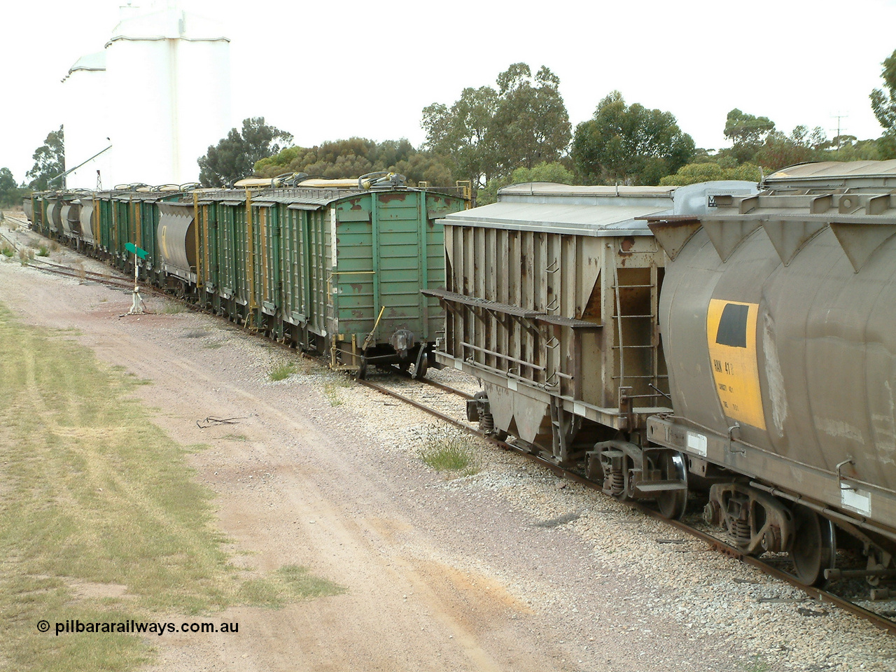 030407 100630
Minnipa, as the front portion shunts away, the make-up of the consist is plain to see. HAN class bogie grain waggon HAN 41, a HBN bogie grain - ballast waggon, and then a motley collection of ENHV, HAN, HBN, HCN and ENHG to round out the consist. 7th April, 2003.
