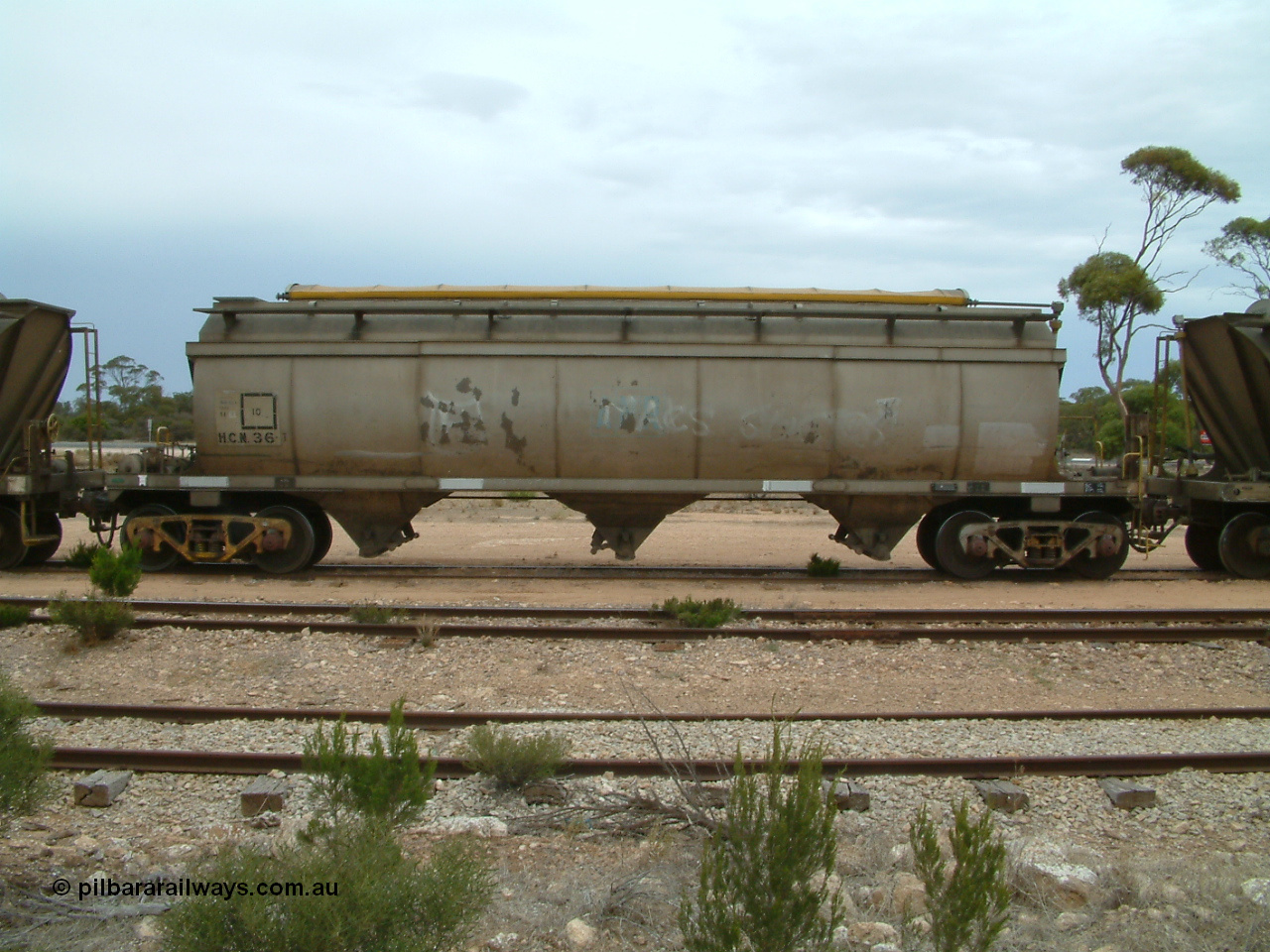 030407 105517
Poochera, track view and side view of HCN type bogie wheat waggon HCN 36, modified at Islington Workshops in 1978-80 which started life as a Tulloch built NHB type iron ore hopper for the CR on the North Australia Railway in 1968-69, showing the roll top covers. 7th April 2003.
Keywords: HCN-type;HCN36;SAR-Islington-WS;rebuild;Tulloch-Ltd-NSW;NHB-type;NHB1592;