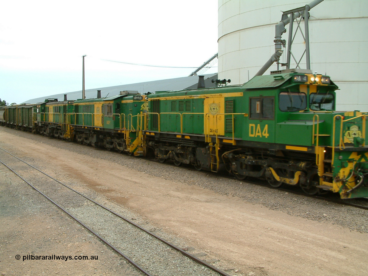 030407 114338
Poochera, empty grain train arrives behind a trio of former Australian National Co-Co locomotives with rebuilt former AE Goodwin ALCo model DL531 830 class ex 839, serial no. 83730, rebuilt by Port Augusta Workshops to DA class, DA 4 leading two AE Goodwin ALCo model DL531 830 class units 842, serial no. 84140 and 851 serial no. 84137, 851 having been on the Eyre Peninsula since delivered in 1962, to shunt off empty waggons and pick up the loaded ones. 7th April 2003.
Keywords: DA-class;DA4;83730;Port-Augusta-WS;ALCo;DL531G/1;830-class;839;rebuild;