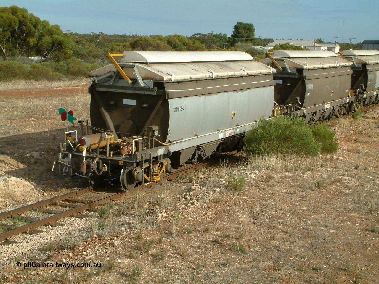 030409 084713
Kyancutta, XNW type bogie grain hopper waggon XNW 12 on the rear of a string of twelve such waggons, Comeng Qld built XNG type bogie waggon for Norseman Goldmines NL, then WAGR owned and coded XNA then in 1994 converted to XNW grain waggons. They arrived on the Eyre Peninsula system from 2001.
Keywords: XNW-type;XNW12;Comeng-Qld;XNG-type;XNA-type;