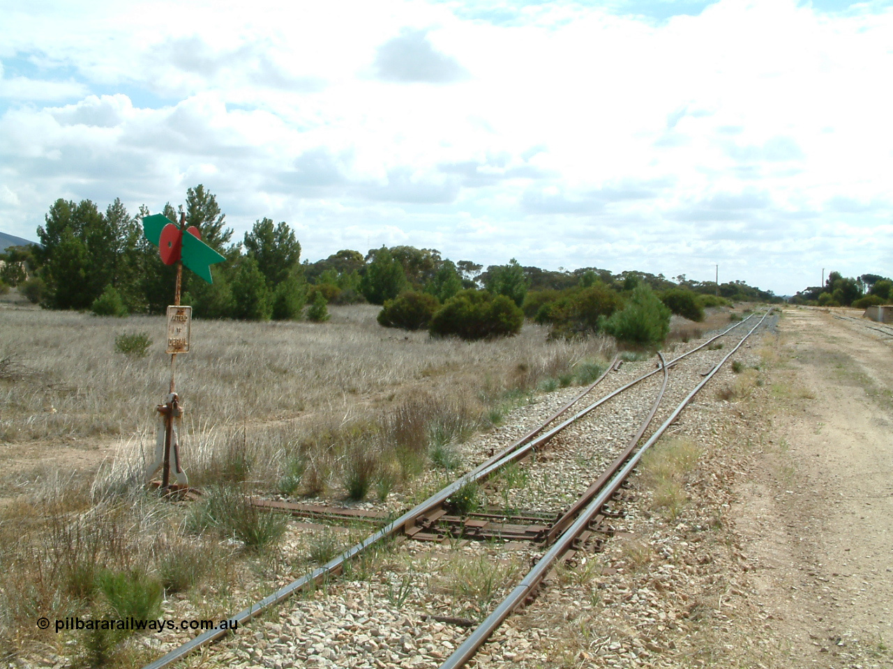 030409 112332
Darke Peake, view looking north from the south end of the triangle, point lever with rail just visible heading into the bush, goods and grain siding with loading ramp at far right.

