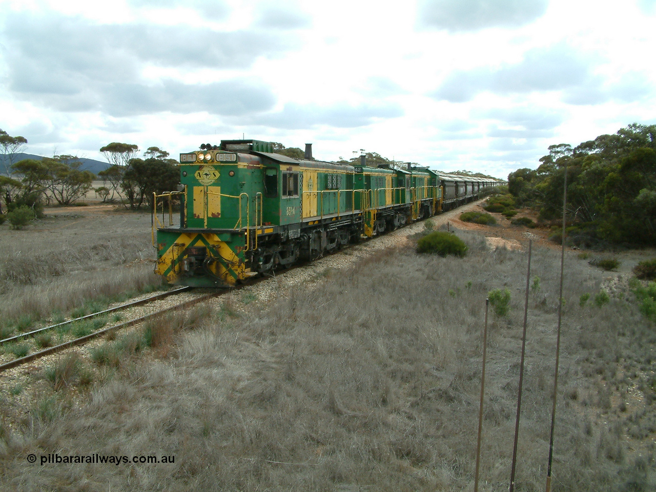 030409 115600
Darke Peake, at the 195 km Dog Fence Road grade crossing loaded grain train with 830 class unit 851 AE Goodwin ALCo model DL531 serial 84137, 851 has spent its entire operating career on the Eyre Peninsula, leads fellow 830 class 842 serial 84140 and a rebuilt unit DA 4, rebuilt from 830 class unit 839 by Port Augusta Workshops, retains original serial 83730 and model DL531 with the first twelve waggons behind the locos XNW type.
Keywords: 830-class;851;AE-Goodwin;ALCo;DL531;84137;