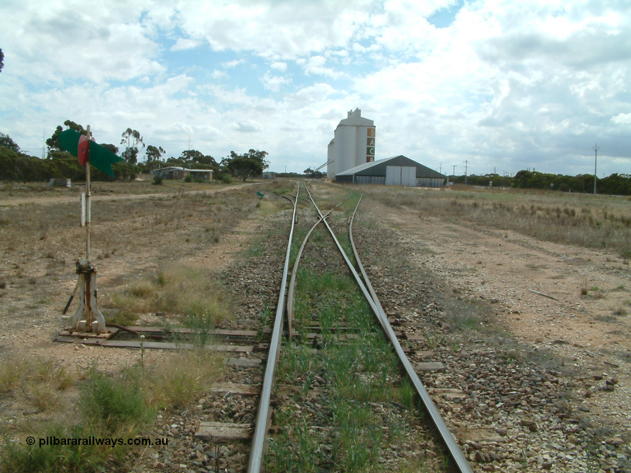 030409 125154
Rudall, station overview of yard looking north from the south end, points to the right for the goods and grain siding, the former station loop, now stub siding on the left, crew barracks and station building further on can be made out, horizontal grain bunker on the right with concrete silo complexes behind.
