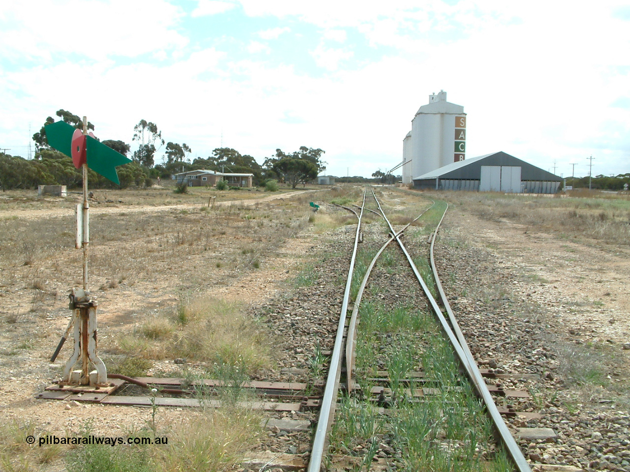 030409 125206
Rudall, station overview of yard looking north from the south end, points to the right for the goods and grain siding, the former station loop, now stub siding on the left, crew barracks and station building further on can be made out, horizontal grain bunker on the right with concrete silo complexes behind.
