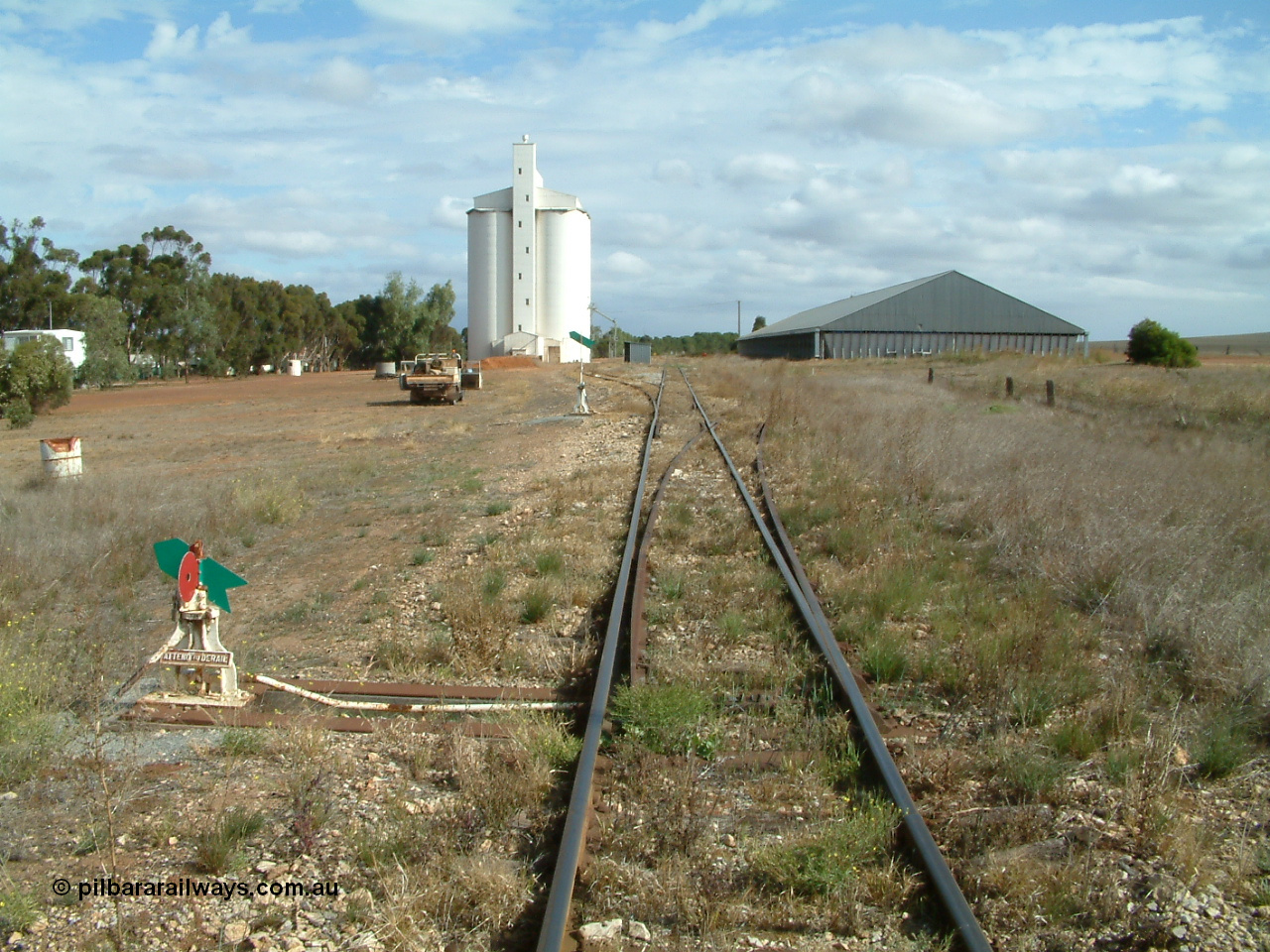 030409 145828
Ungarra, located at the 108.1 km and opened in March 1913 as the temporary terminus till July 1913. Yard overview looking south from the north end, loading ramp can be made out in front of car, silo complex, station hut then the horizontal grain bunker on the right.
