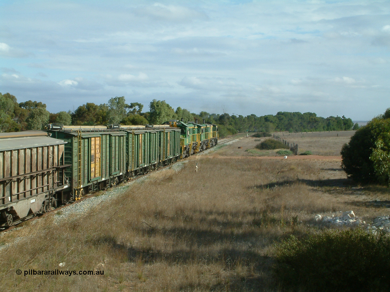 030409 152437
Ungarra, the peace is shattered as a loaded grain train storms upgrade through the station behind 830 class unit 851 AE Goodwin ALCo model DL531 serial 84137, fellow 830 class 842 serial 84140 and a rebuilt DA class unit DA 4 trailing view with the ENHV waggons as the continue south.
Keywords: ENHV-type;Societe-Gregg-de-Europ;NVD-type;ENBA-type;