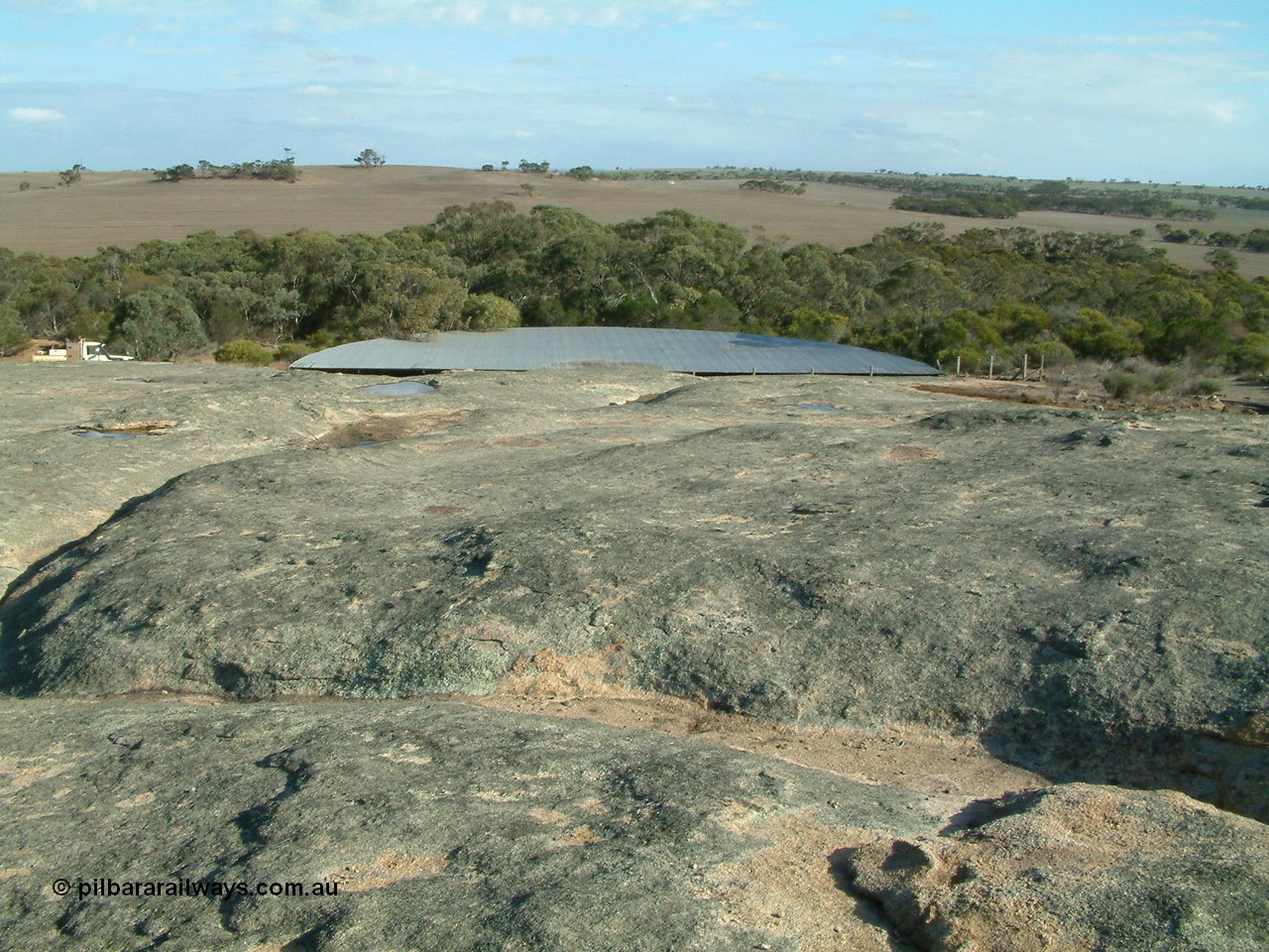 030409 155132
Moody Tank, view of the granite rock which acts as the catchment for the tank, water can be seen in pools, the line is below within the trees.
