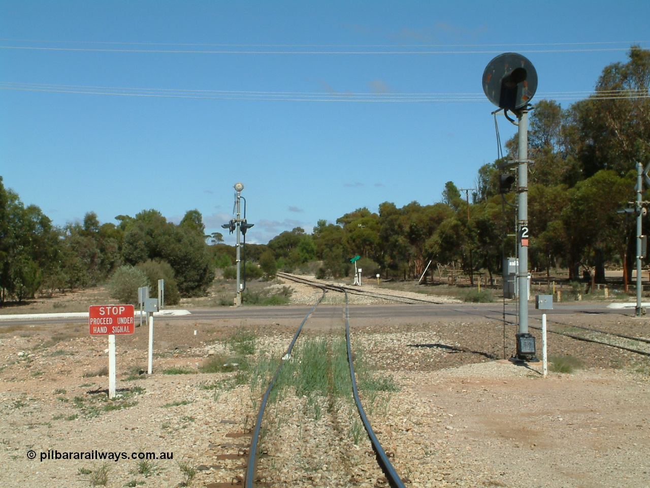030411 110811
Kimba, looking south across the Eyre Highway grade crossing, the grain road has to use hand signals, the mainline has a coloured light, one of only three such signals on the Eyre Peninsula system, the others being at Kyancutta and Port Lincoln.
