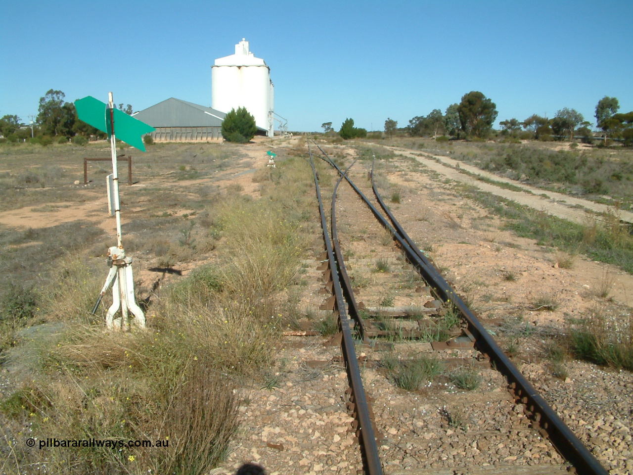 030411 154018
Wirrulla 333.2 km, yard overview looking south from the Thevenard end on Gawler Ranges Road, horizontal bunker with two blocks of concrete silos on the left.
