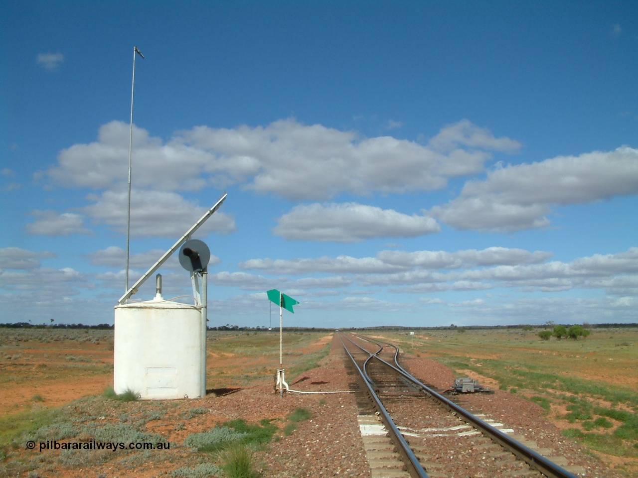 030415 150814
Ferguson, located at the 469 km on the Trans Australian Railway, looking east at the west end of the 1800 metre long crossing loop, point work on timber sleepers, interlocking hut, indicator and lever with dual control point machine on the right. [url=https://goo.gl/maps/XNaMGCNxZ4yv7Lrr9]GeoData location[/url].
