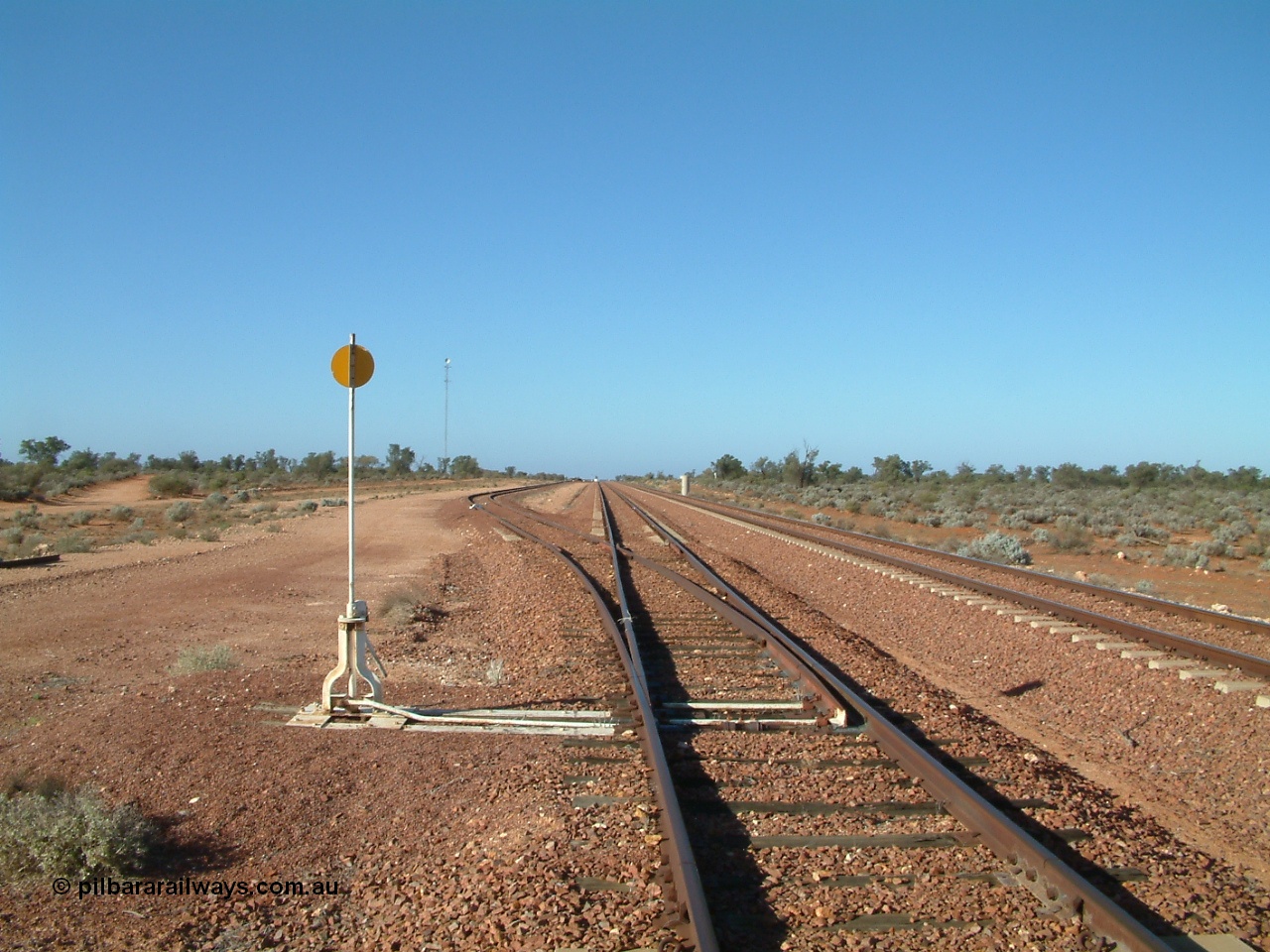 030416 084242
Carnes Siding located at the 566.4 km on the Central Australian line from Tarcoola to Alice Springs. View looking south from the north end of the goods siding rejoining the loop and the mainline at right. The train control 'pillbox' concrete hut is visible with the station nameboard the white item beside it. [url=https://goo.gl/maps/QbycvbbHxJHLg8h87]GeoData location[/url]. 16th April 2003.

